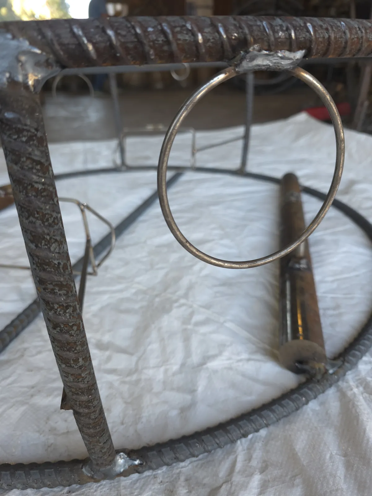 Escape ring hanging from the top rebar ring of a bare CCP trap, its top welded to the ring, before wire and wrap