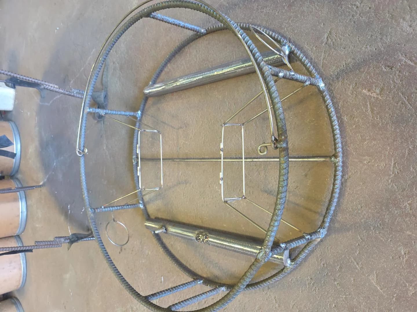 Bare CCP rebar frame from above showing circular rings, uprights, dual weight bars, center support and tunnel frames