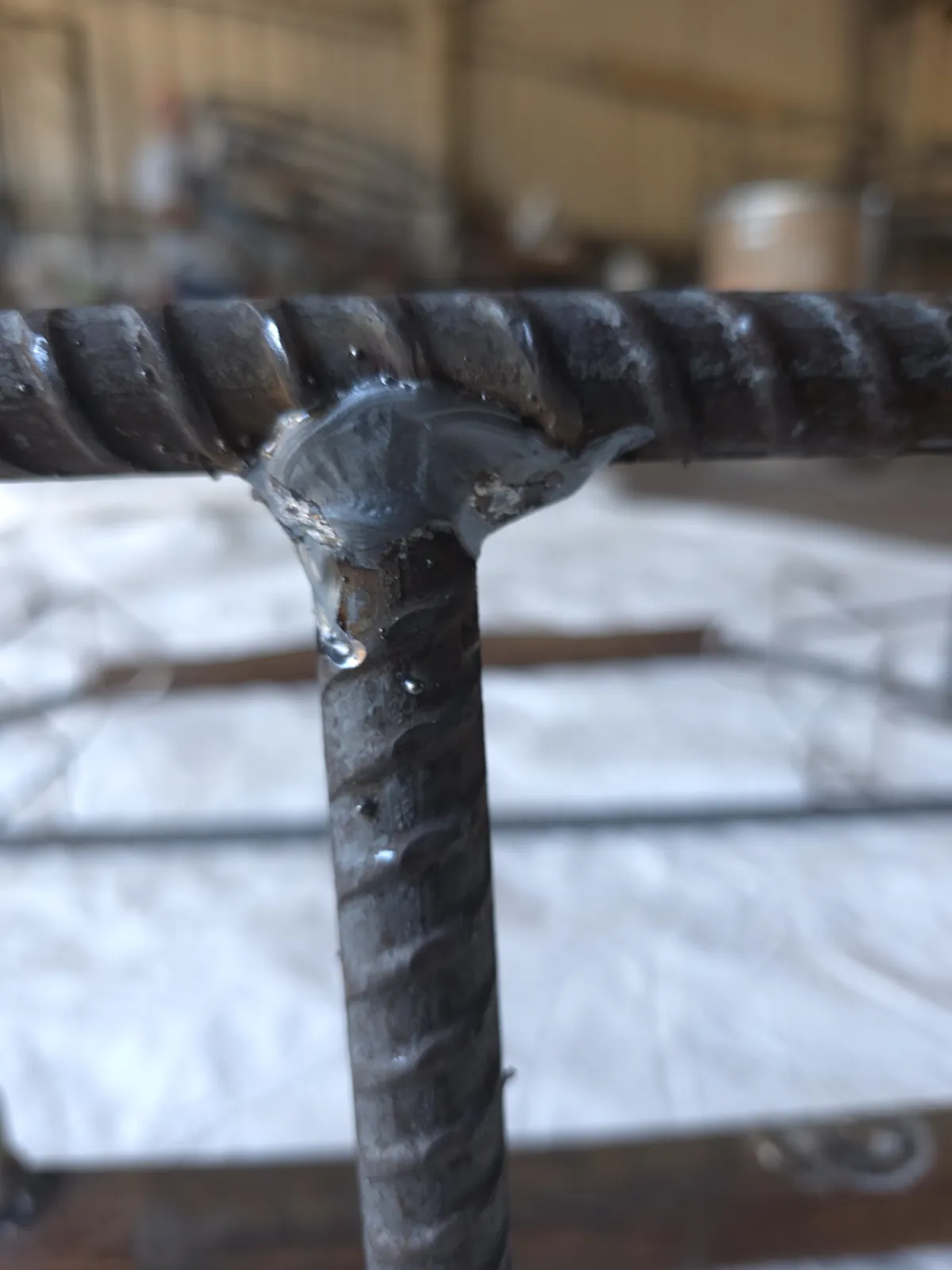 Close view of the weld joining a rebar stanchion to the top ring of a bare CCP trap