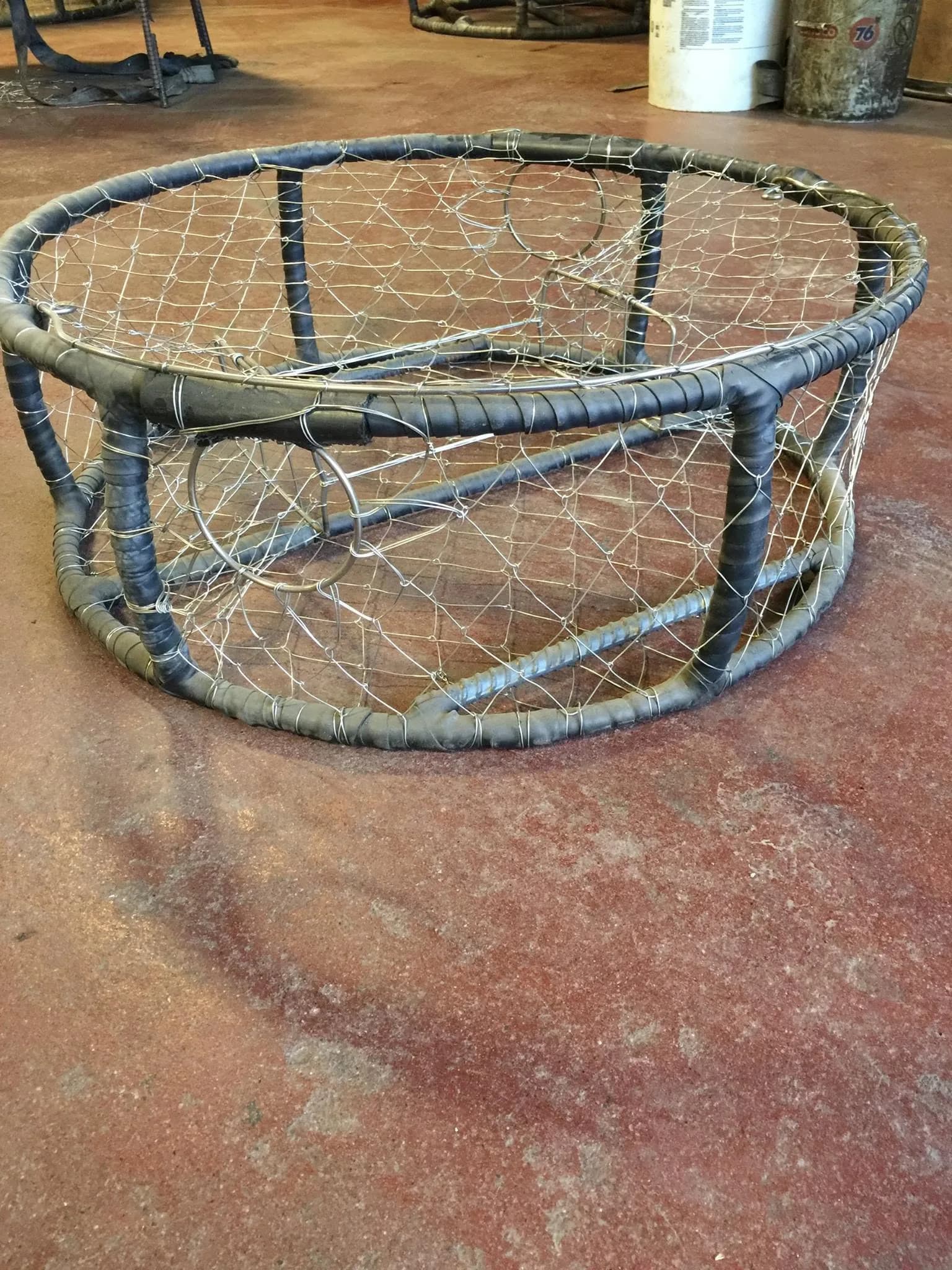 Single finished CCP pot on the shop floor showing wrapped frame, knitted wire and side entry tunnels