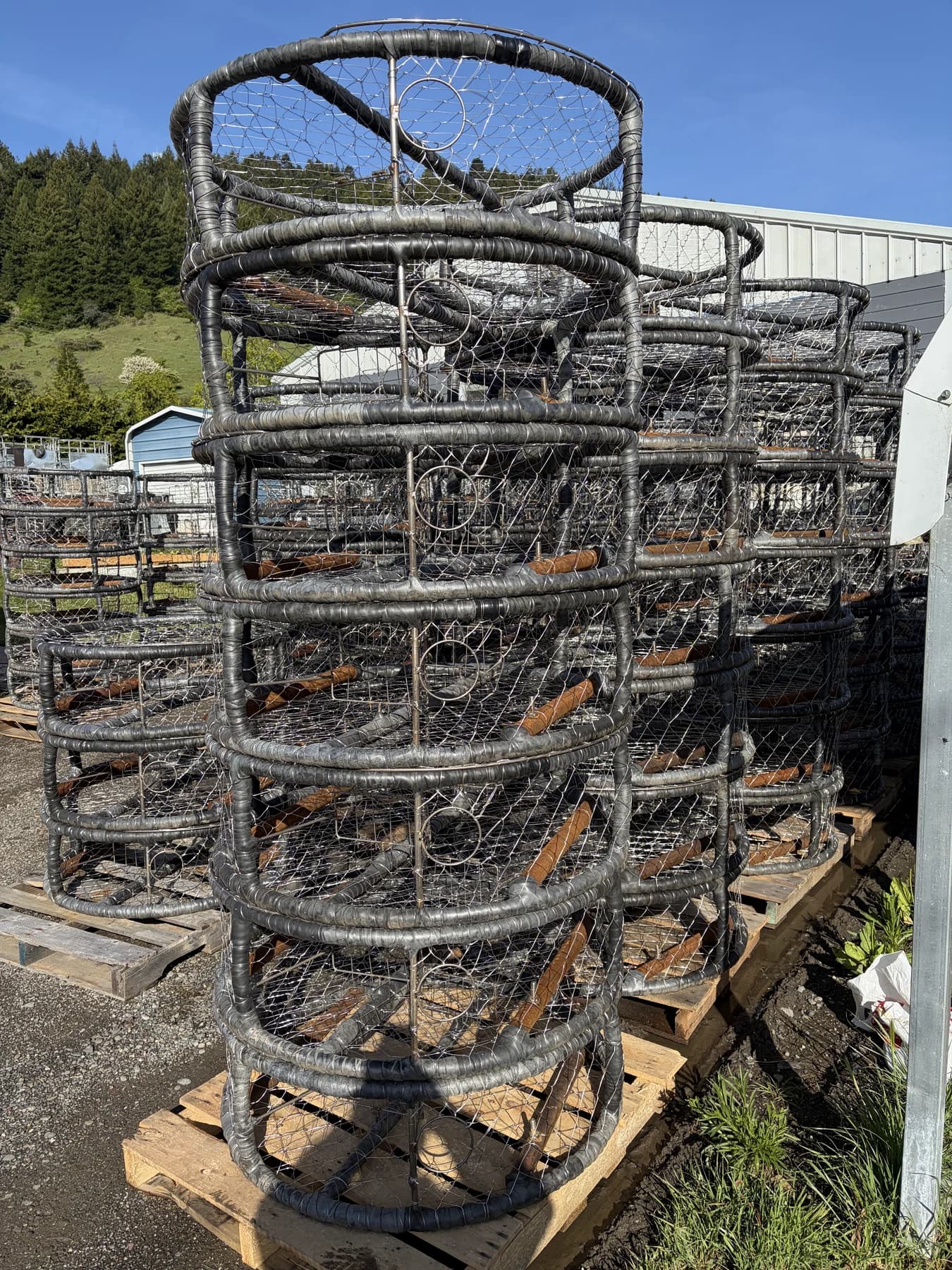 Angled side view of stacked CCP pots showing wrapped frames, wirework, and escape rings