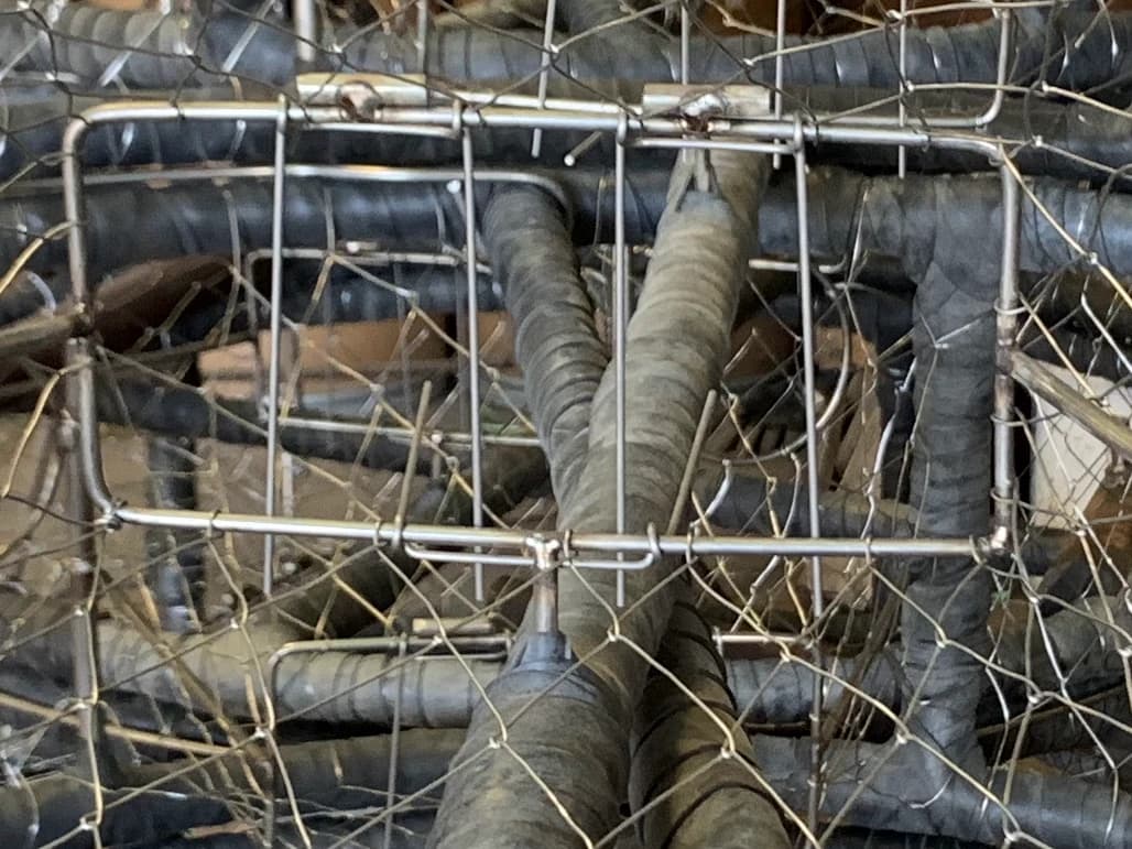 Close view of hanging trigger rods across the rectangular inner opening of a CCP tunnel