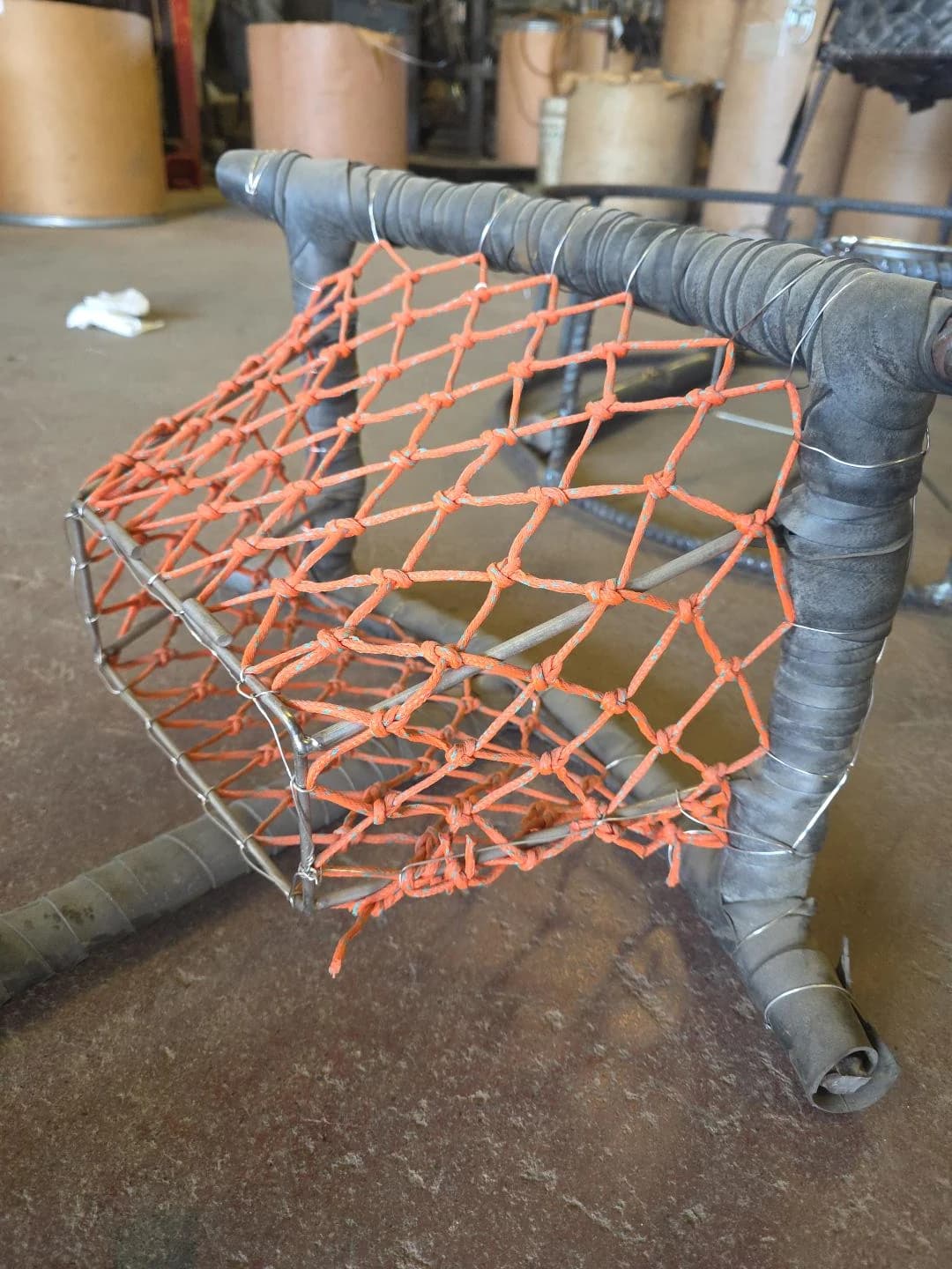 Side view of the orange braided tunnel showing its sloping sides and recessed opening