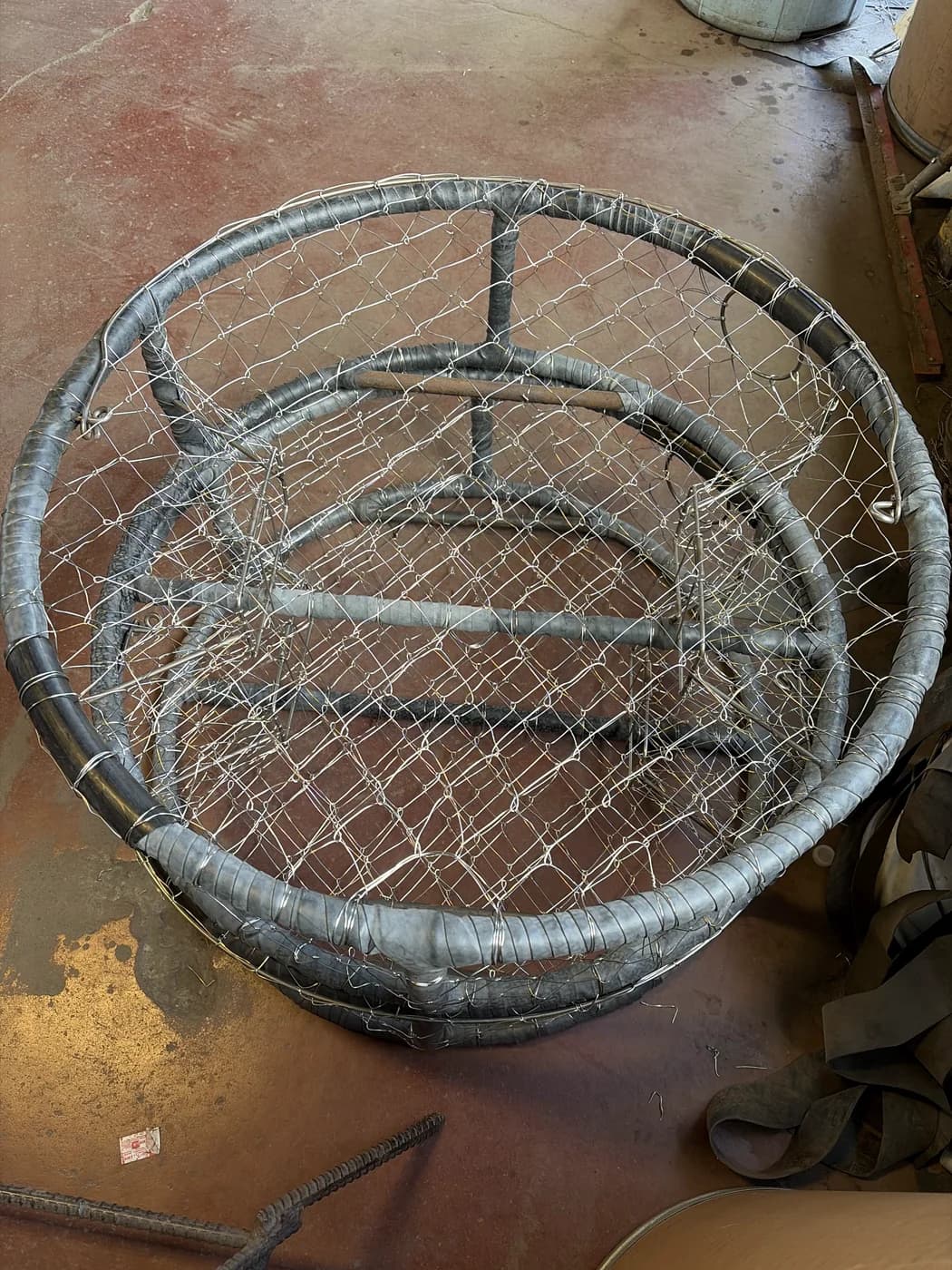 Overhead view of hand-knitted wire across a CCP pot, with its crossbars and two tunnel openings visible