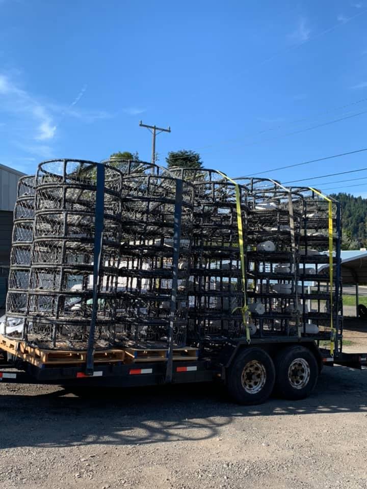Dual-axle trailer stacked with finished wrapped crab pots ready to leave the shop